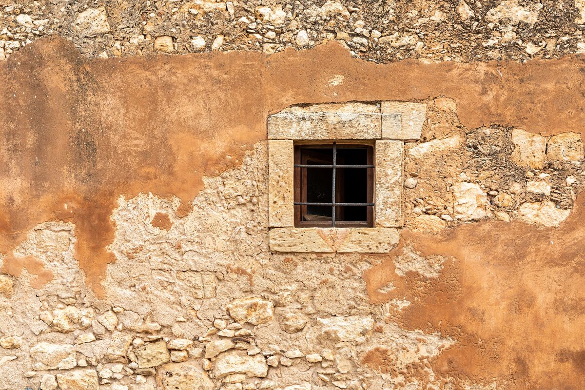 The ornate Venetian-style facade of the church of the Arkadi Monastery in a stone courtyard