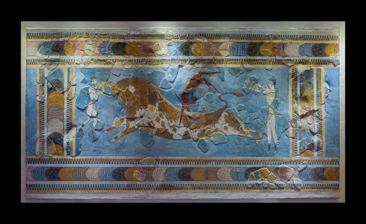 The Minoan bull-leaping fresco from Knossos, showing an acrobat somersaulting over the back of a charging bull while two figures stand at its head and tail