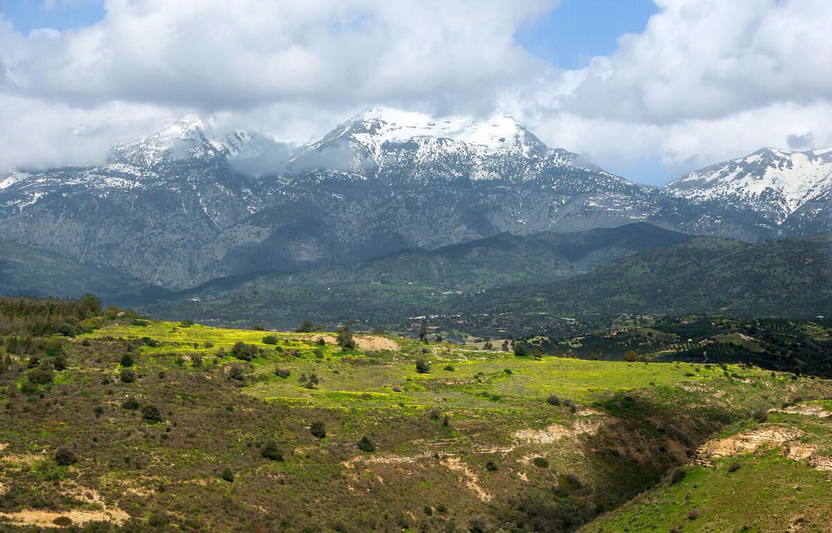 View from Phaistos over green hills and fields to the snow-capped peaks of Mount Ida (Psiloritis)