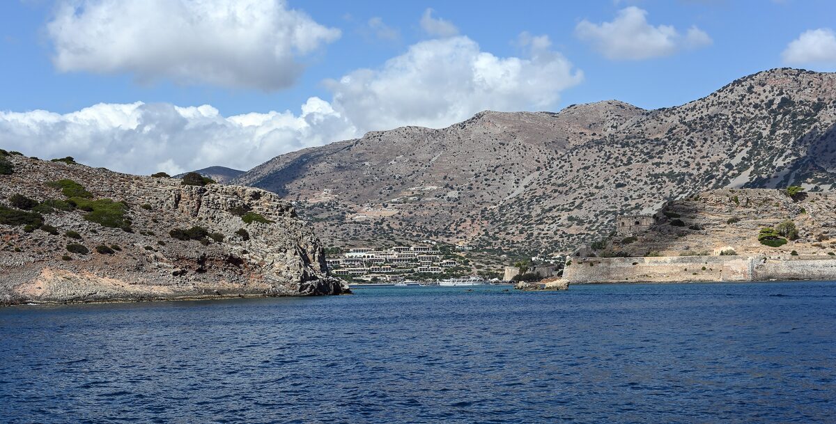 The island of Spinalonga with its Venetian fortress walls, seen across the turquoise water from the village of Plaka