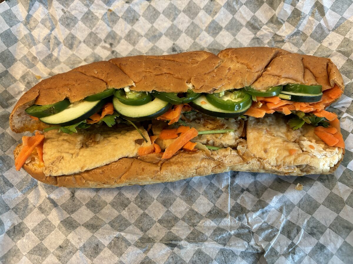 A crisp baguette filled with tofu, sliced cucumber, pickled carrot and chili