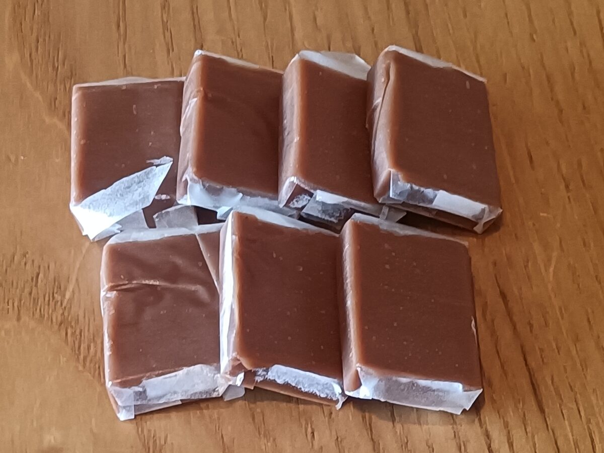 Wrapped squares of Bến Tre cocoa-coconut candy on a wooden table
