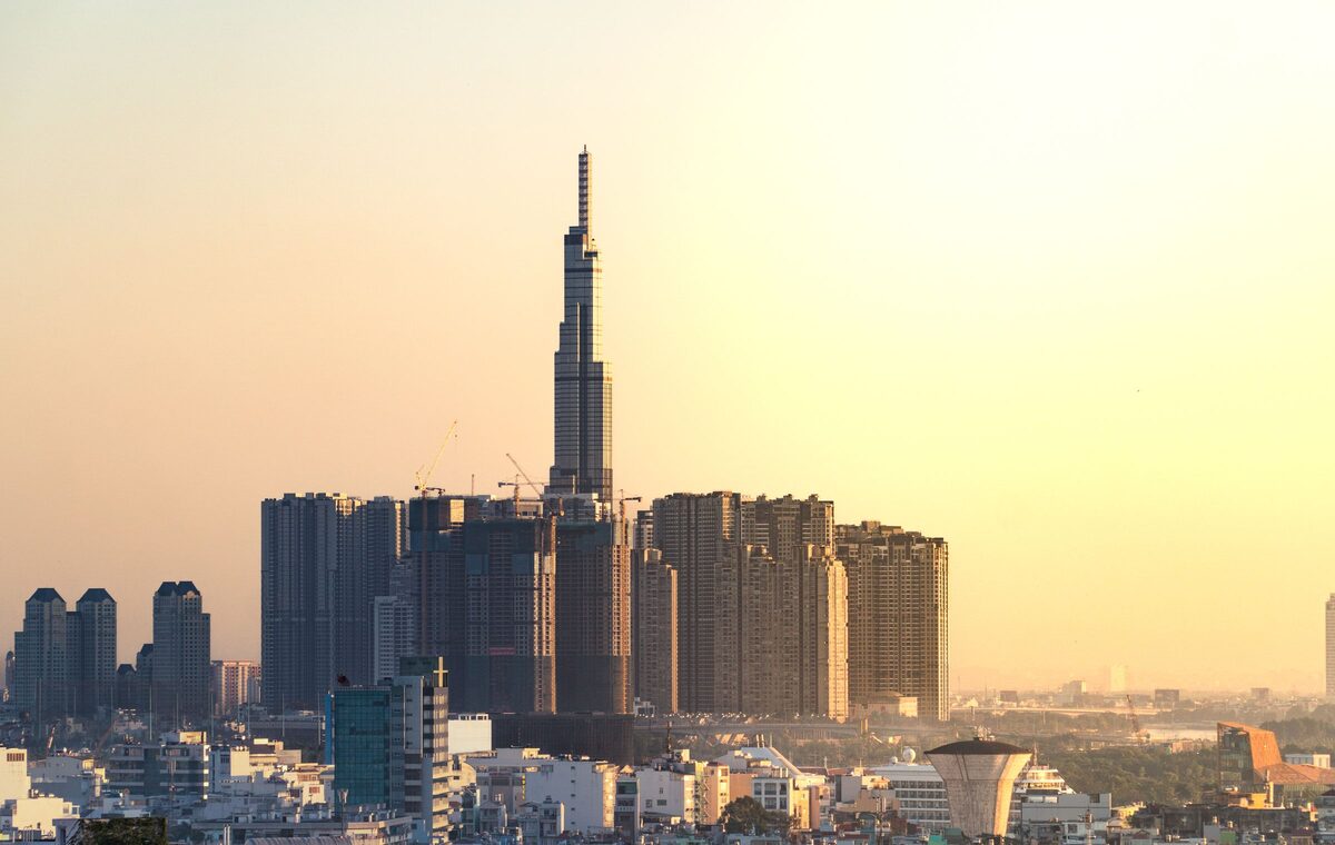 Landmark 81 rising above the apartment towers of Bình Thạnh in a hazy golden light