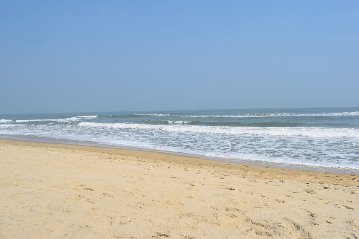 Waves rolling onto the sand at An Bang beach on a bright day, with almost nobody in the water