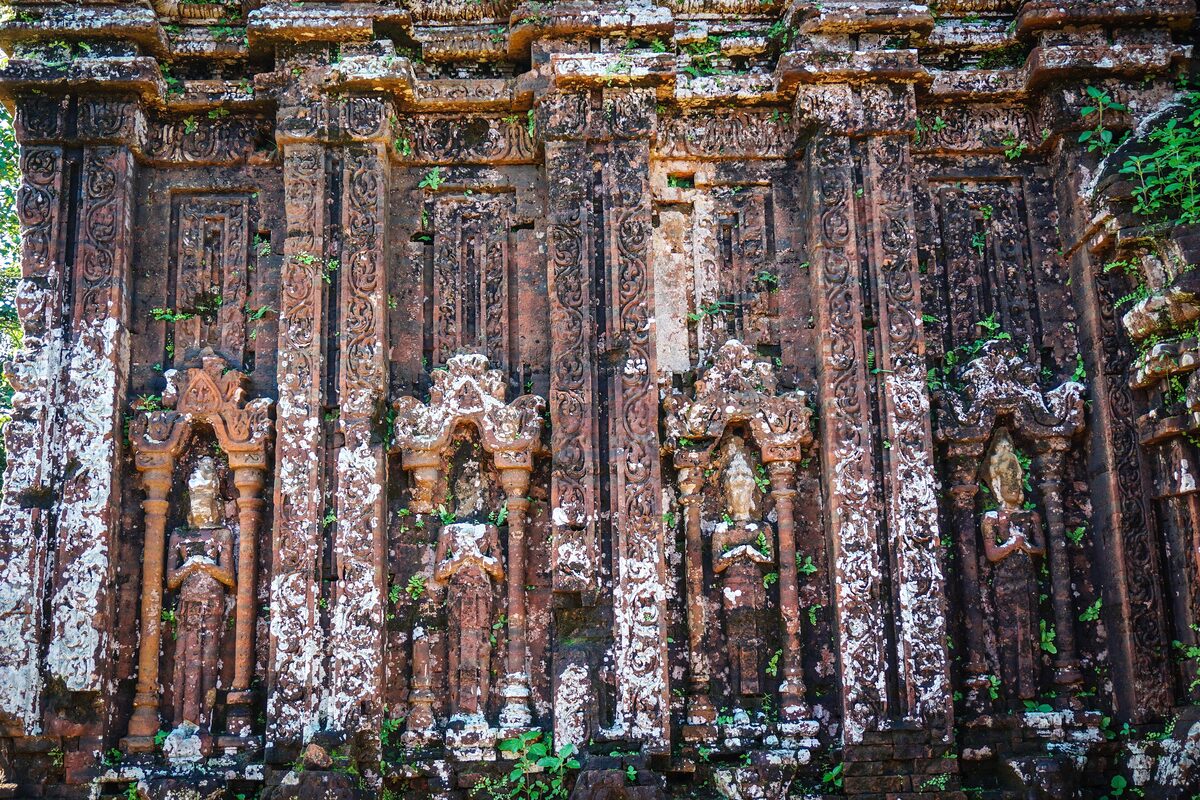 Carved brick towers of a My Son sanctuary temple, with stone figures in the niches