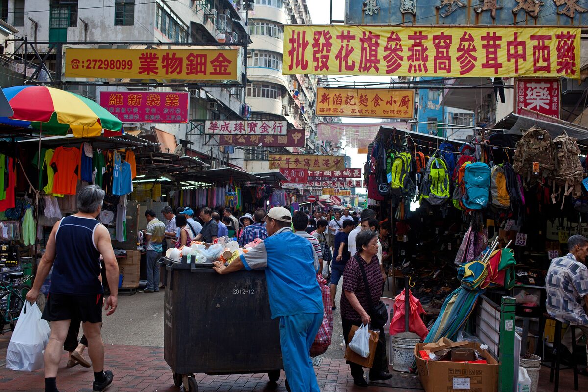 Crowded Apliu Street in Sham Shui Po, with market stalls under bright shop signs and shoppers filling the lane