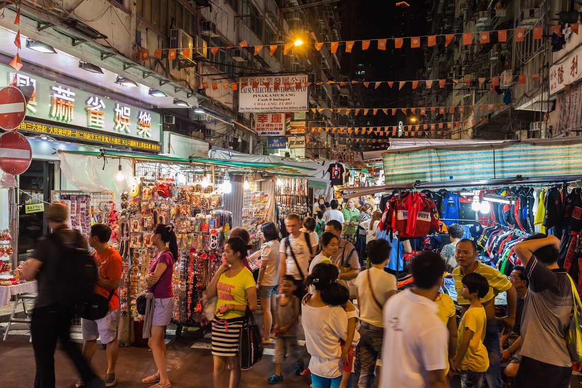 Crowds browsing the stalls of Temple Street Night Market under strings of lights