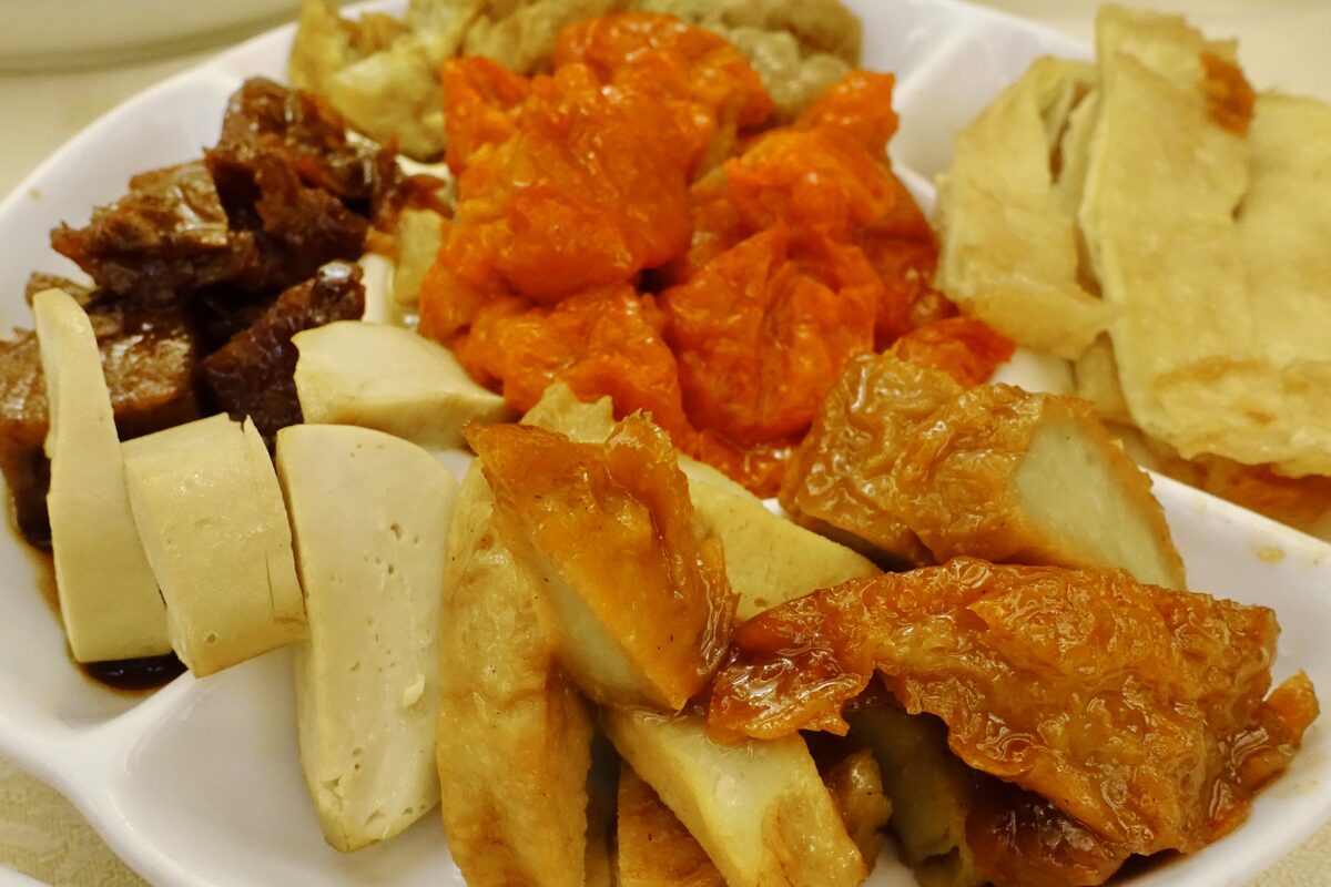 A plate of Buddhist-style vegetarian dishes in Hong Kong: sliced bean curd, fried tofu skin and braised mock meat in sauce