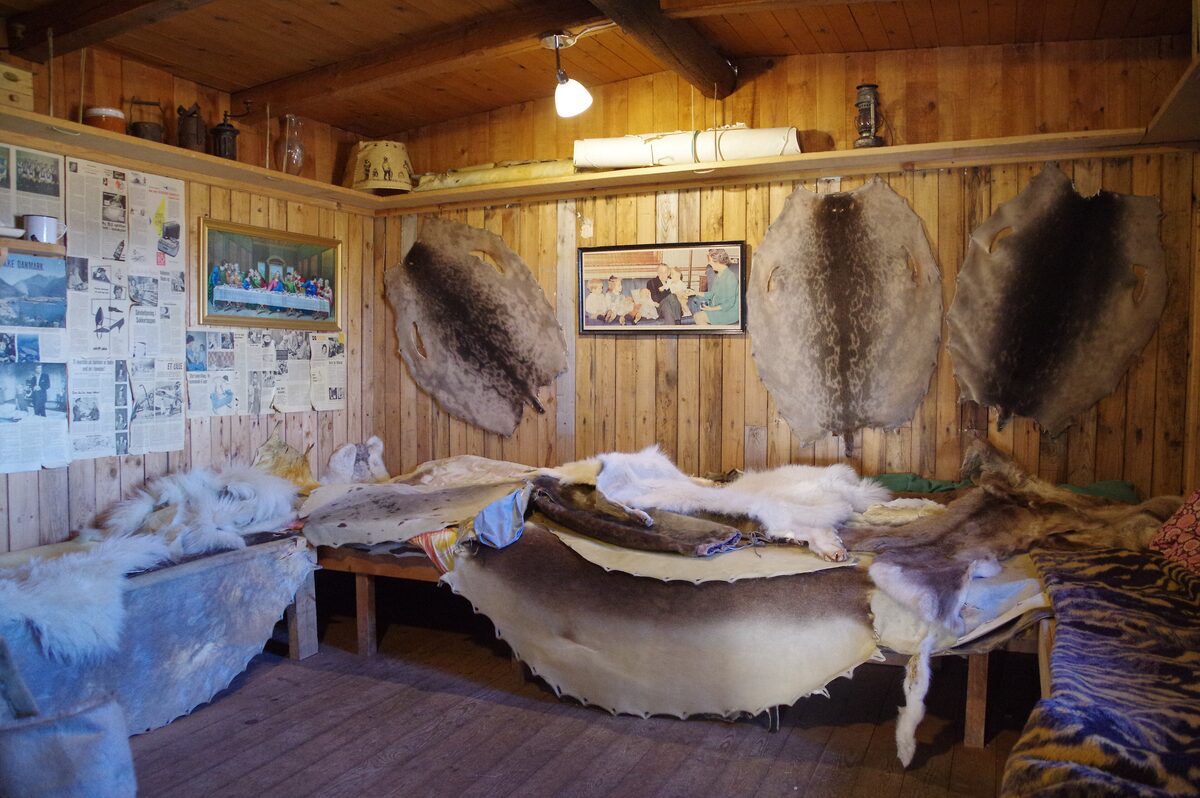 Inside the Ilulissat Museum, with sealskins hung on the wooden walls and laid over a bench under old photographs