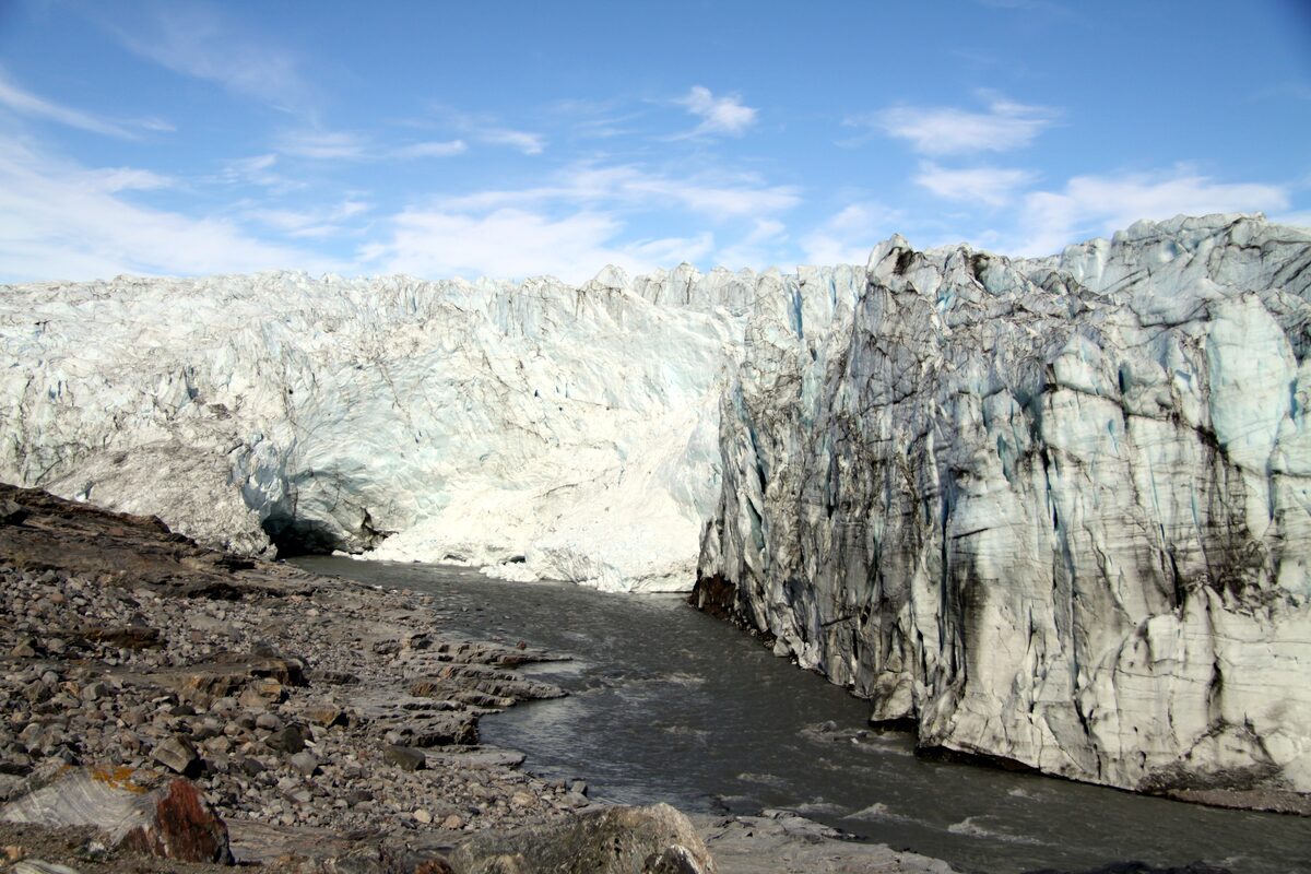 The ice margin at Russell Glacier, a white ice wall above dark gravel and meltwater near Kangerlussuaq