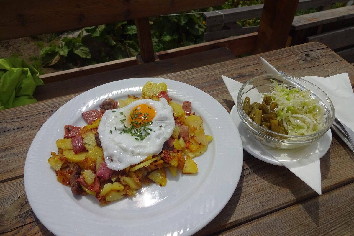 Tiroler Gröstl, fried potatoes with bacon and onions topped with a fried egg, with a side of cabbage salad