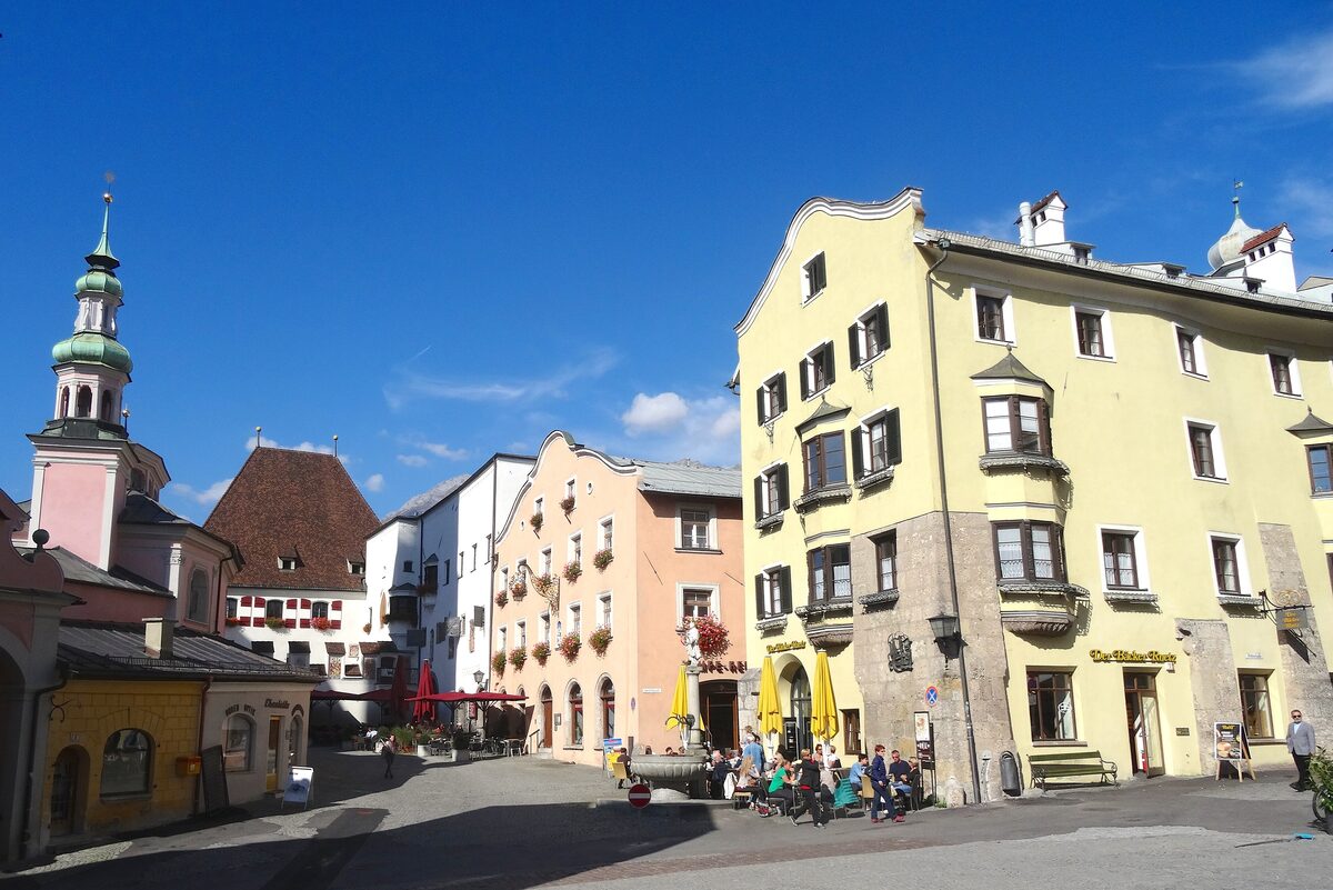 Colorful old houses on the upper town square of Hall in Tirol, with the parish church tower