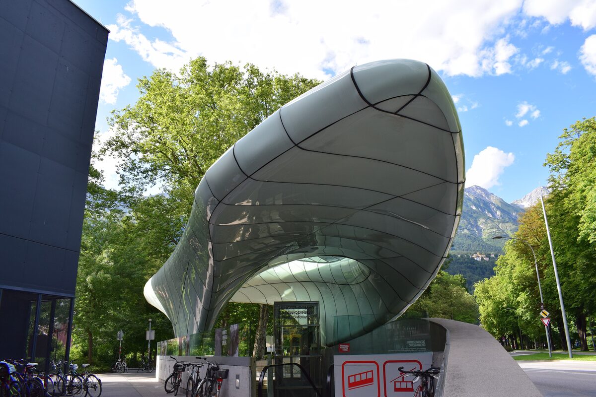 Congress station of the Hungerburg funicular by Zaha Hadid, a flowing glass roof like a sheet of ice, with mountains behind