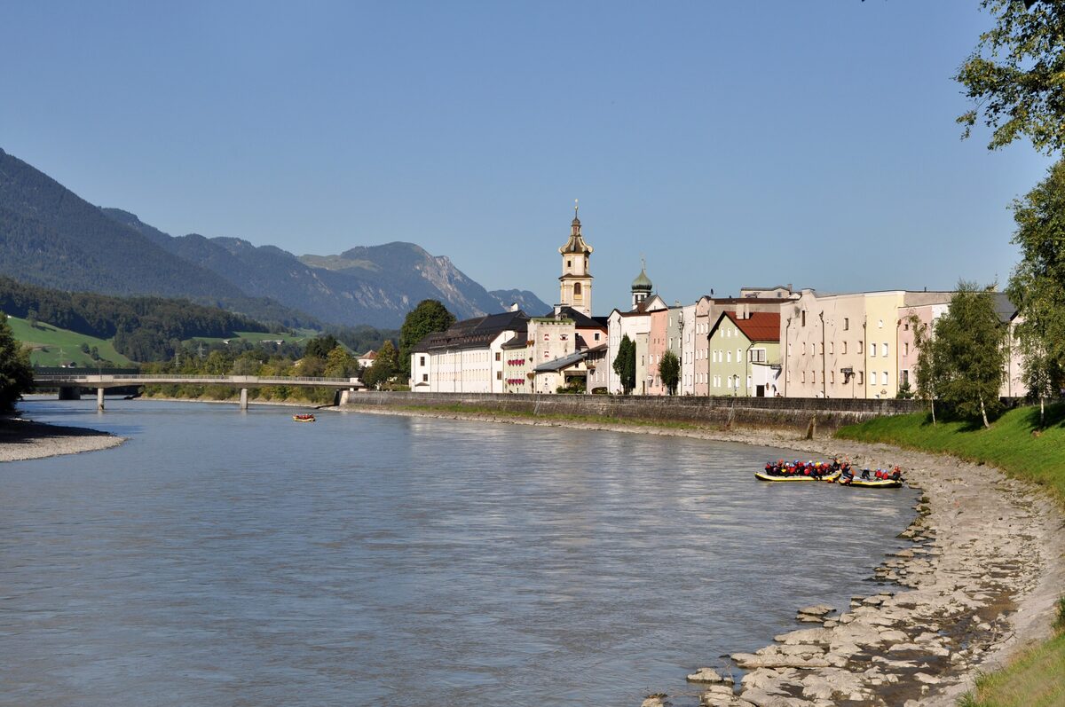 Rattenberg's old houses and church tower on the bank of the Inn, with mountains behind