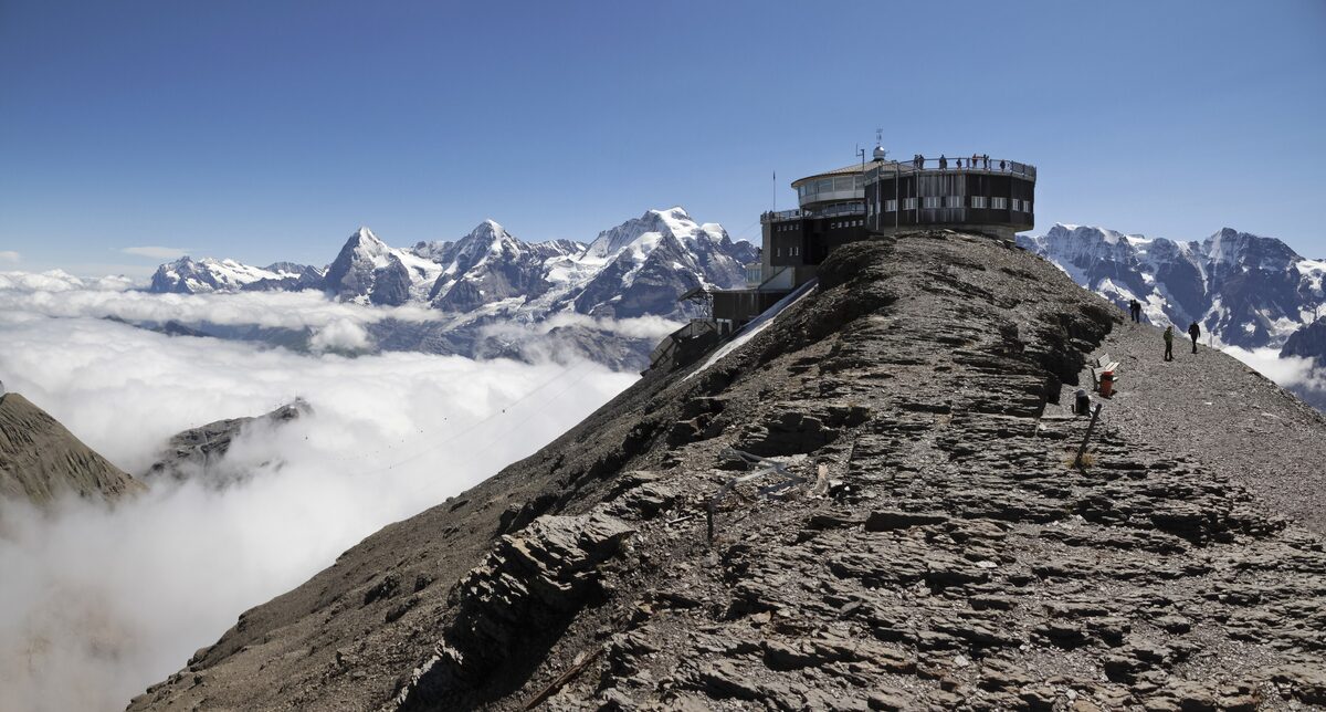 The Piz Gloria station on the Schilthorn ridge, with clouds below the peaks of the Bernese Alps