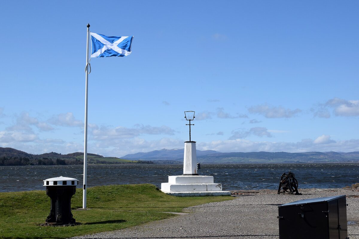 The end of the Caledonian Canal at Clachnaharry sea lock, with a Saltire flag and the Beauly Firth beyond