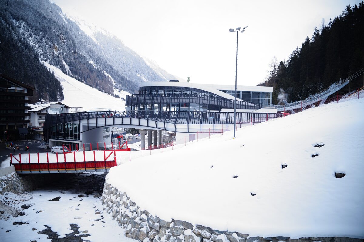 The Pardatschgratbahn valley station in Ischgl under fresh snow, with a pine slope and a mountain behind