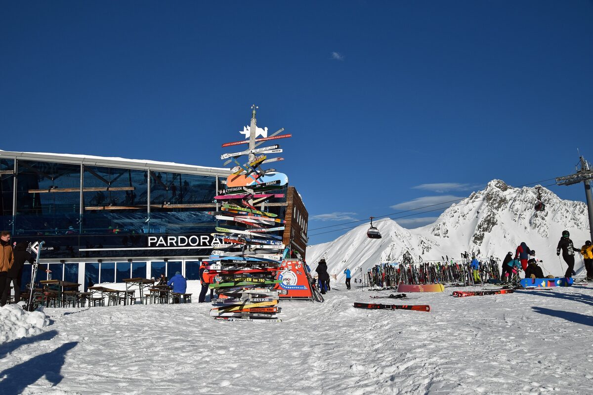 The Pardorama restaurant on the Pardatschgrat with skiers outside and a totem pole of ski signs