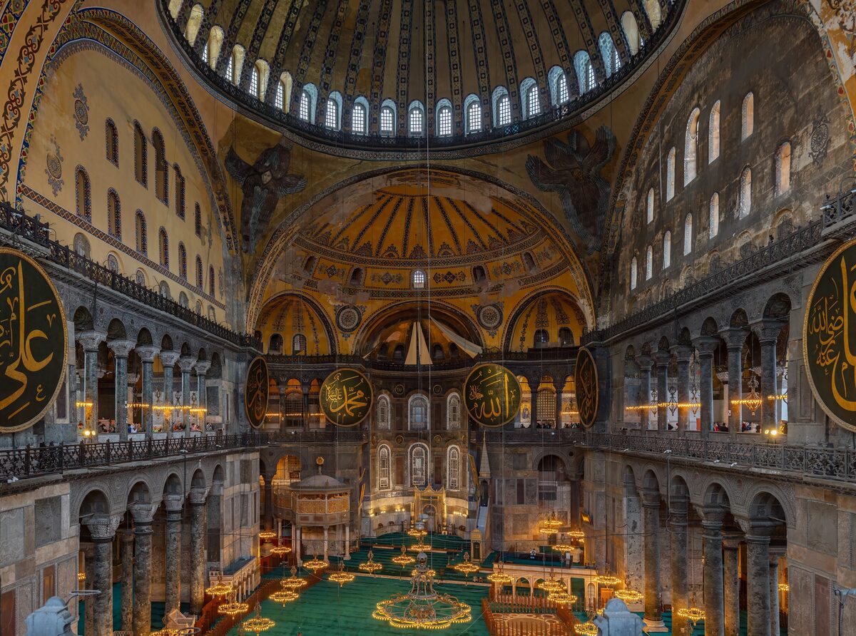 Inside Hagia Sophia from the upper gallery: the great dome, the gold apse with the mosaic of the Virgin and Child, huge calligraphy roundels and the prayer floor below