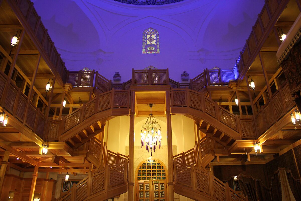 The domed entrance hall of the Hürrem Sultan Hammam, with carved wooden galleries and stairs around a chandelier