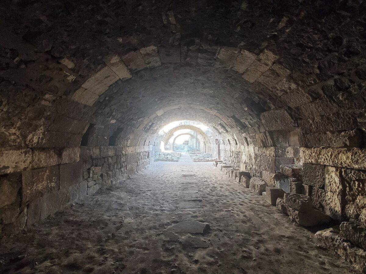 A long stone-vaulted corridor under the basilica of the Agora of Smyrna, with light at the far end