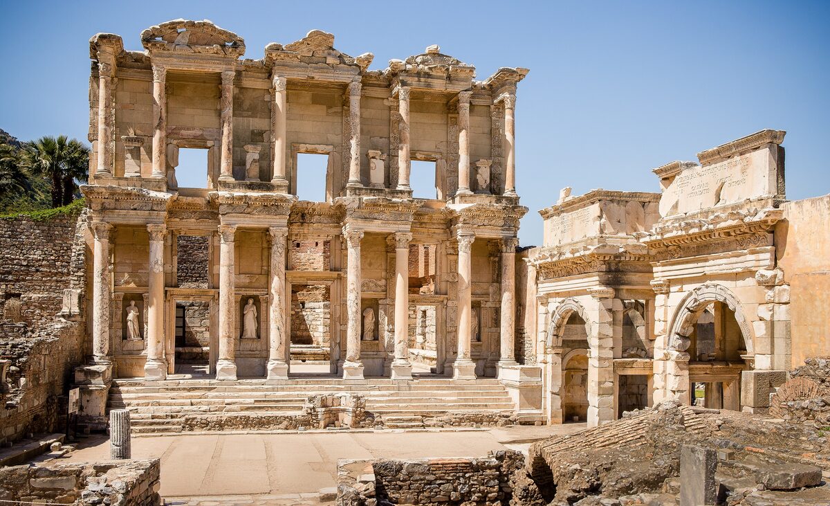 The two-storey marble facade of the Library of Celsus at Ephesus, with its columns and statues in niches, lit by the morning sun