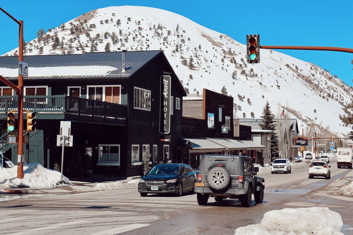A Jackson street corner in winter, with snow banks and a snow-covered hill rising behind the buildings