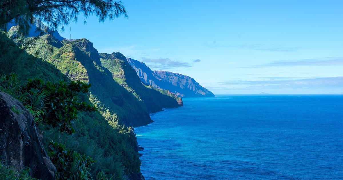 The green fluted cliffs of the Nā Pali Coast rising straight out of the Pacific on Kauai