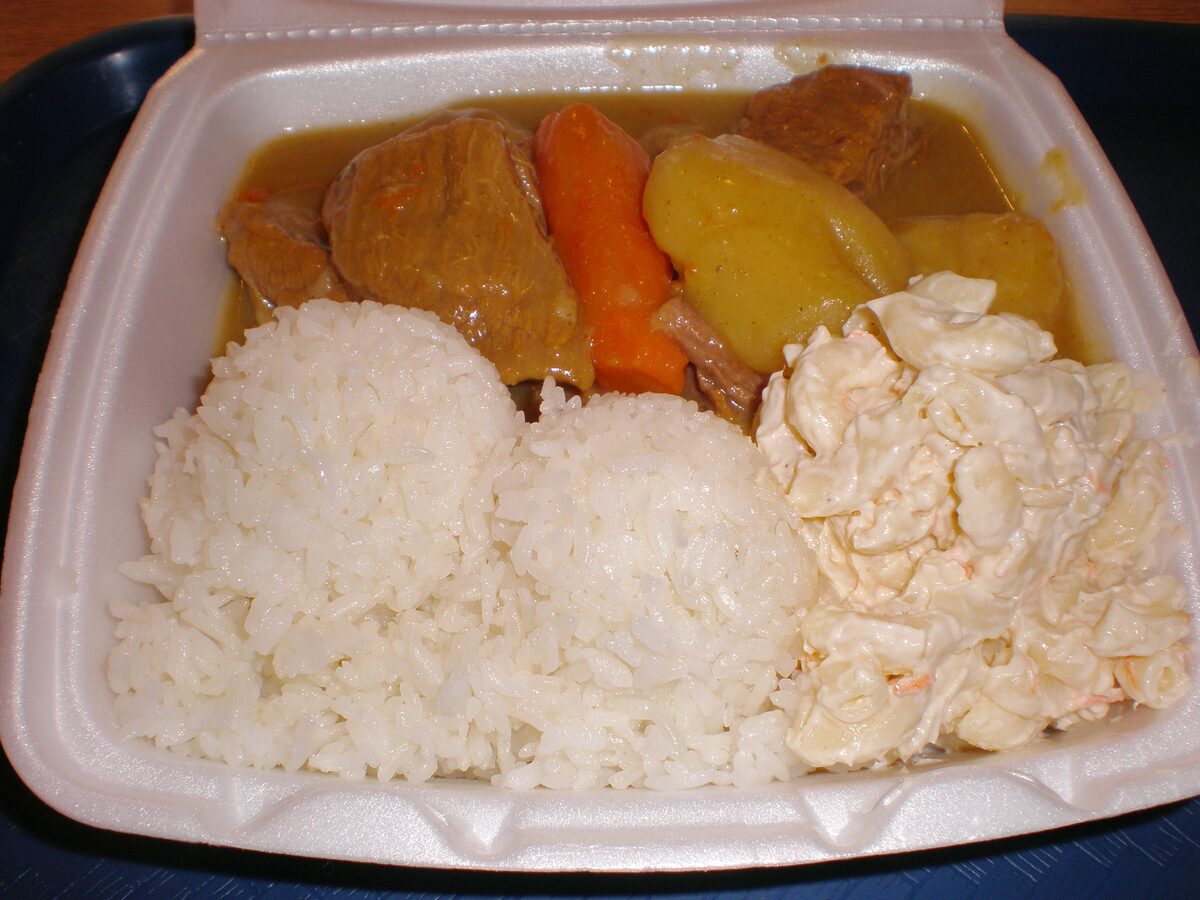 A takeout plate lunch of rice, macaroni salad and curry