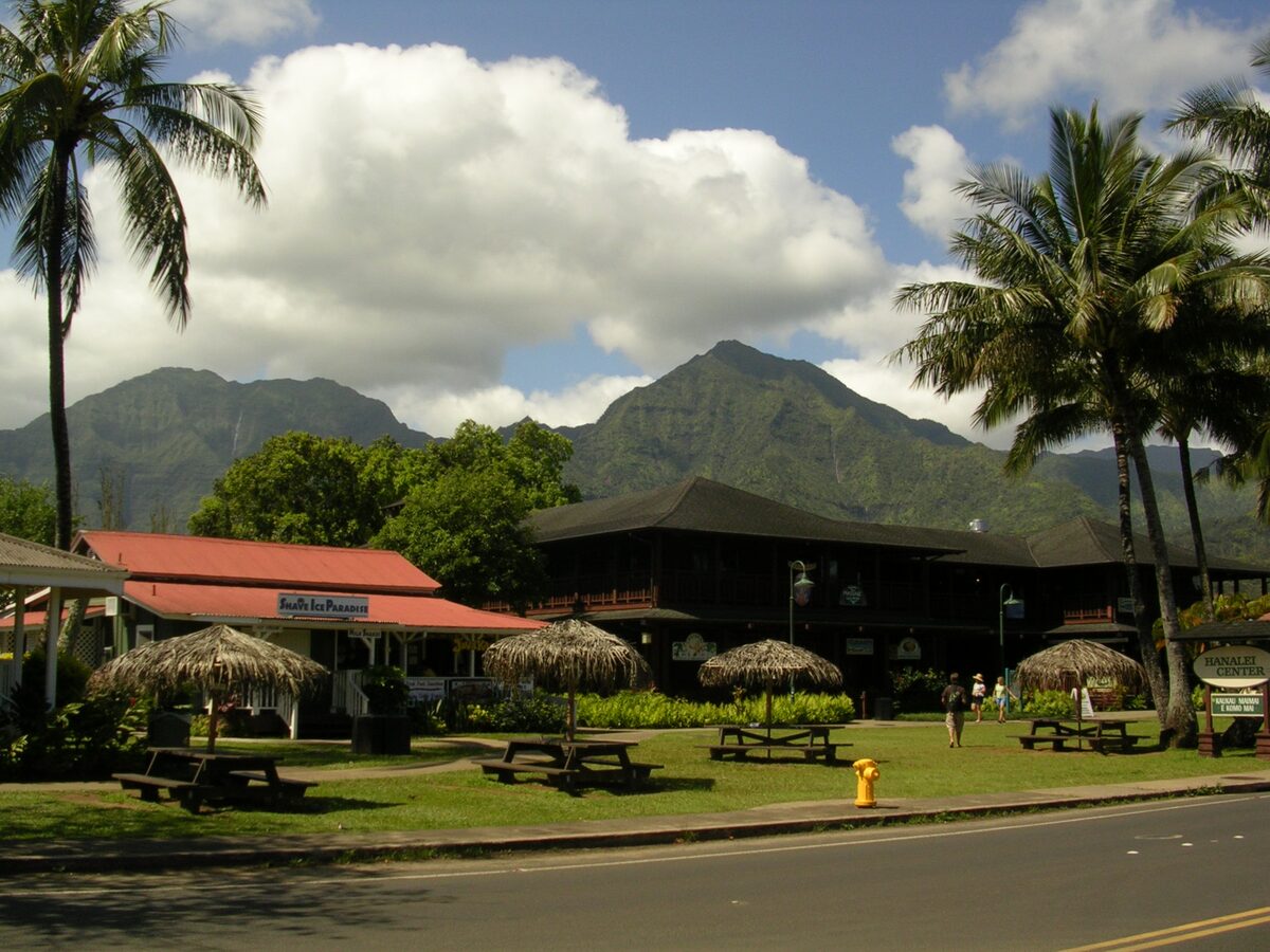 Hanalei town shops and picnic umbrellas below green mountains