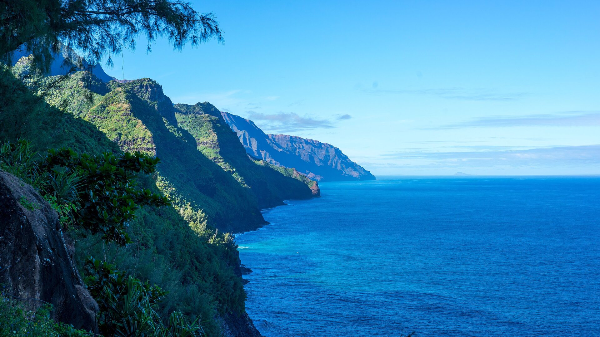 The green fluted cliffs of the Nā Pali Coast rising straight out of the Pacific on Kauai