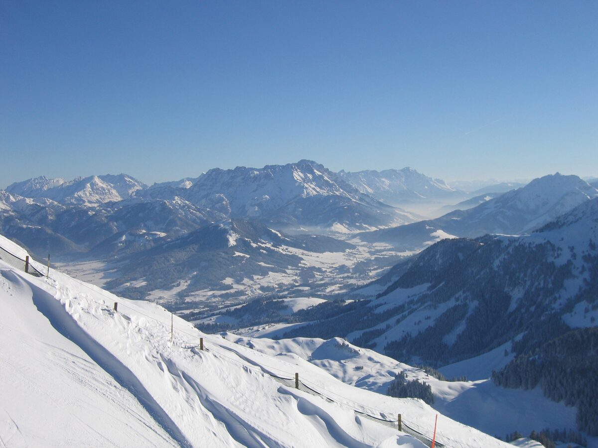 View from the Kitzbüheler Horn over a snow-covered ridge to the valley and the Leoganger Steinberge on a clear winter day