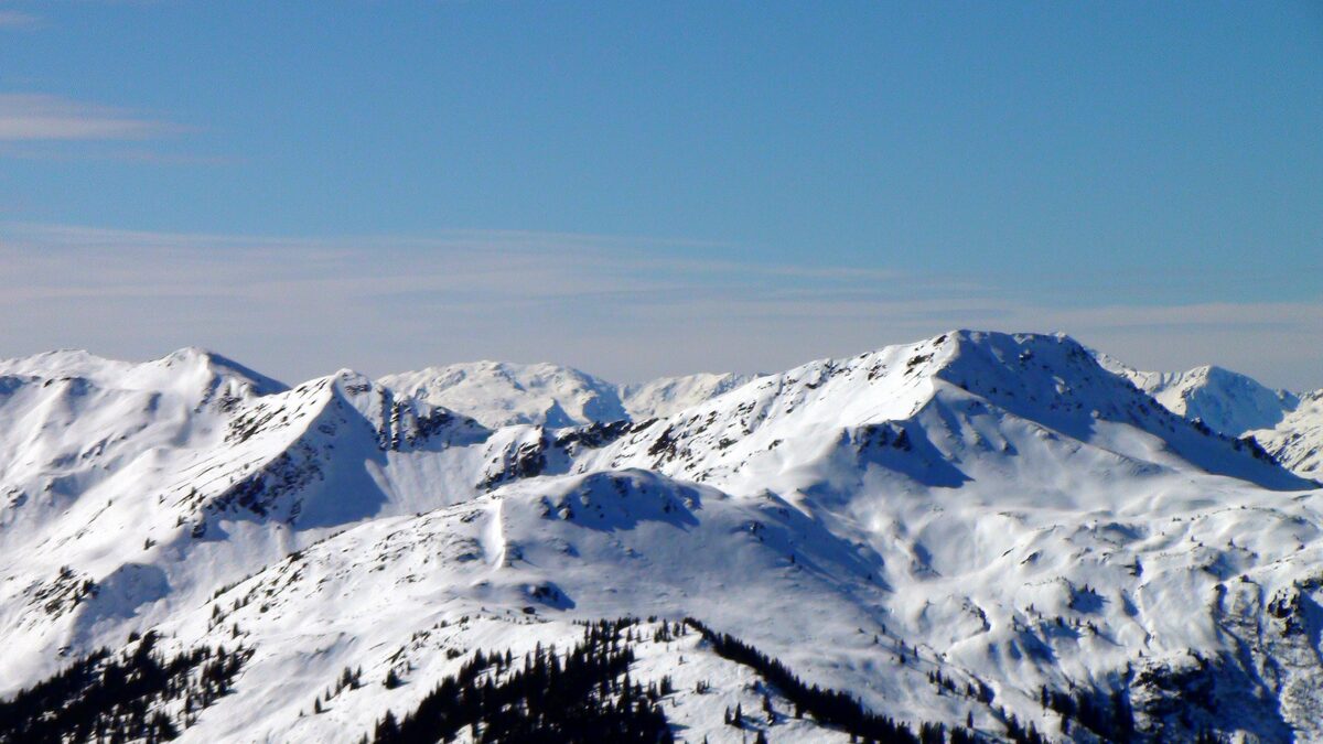Snow-covered peaks of the Kitzbüheler Alpen under a blue sky, seen from the Pengelstein top station