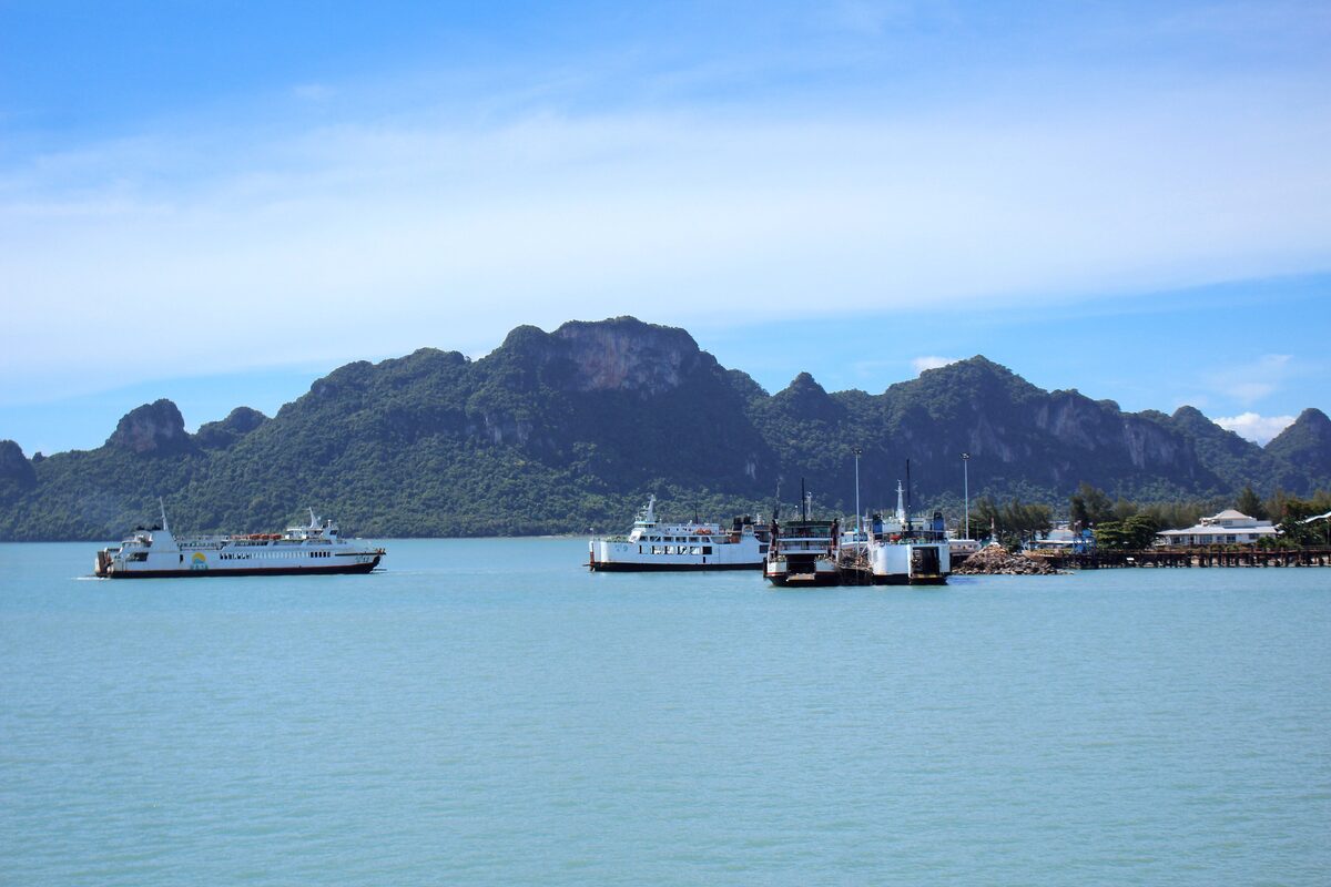 Raja Ferry Pier at Don Sak, with ferries tied up and hills across the water