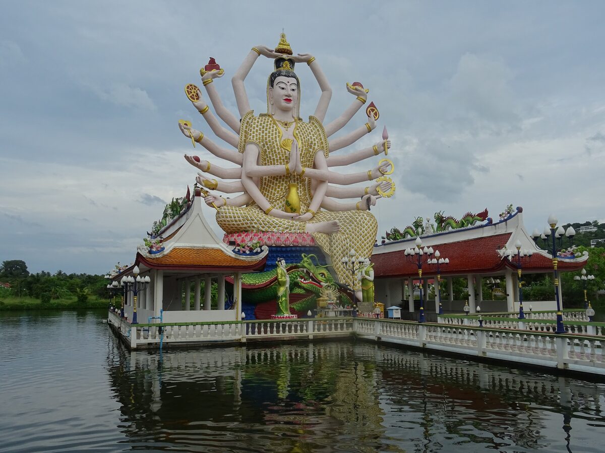 The eighteen-armed Guanyin standing in an open pavilion on the lake at Wat Plai Laem