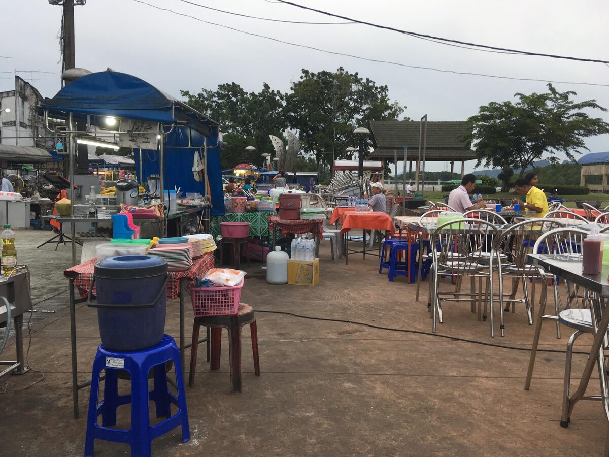 Market stalls with plastic tables and stools at the Krabi Town food market