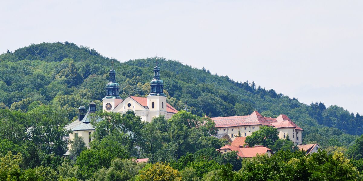 The baroque monastery of Kalwaria Zebrzydowska with its two towers among wooded hills