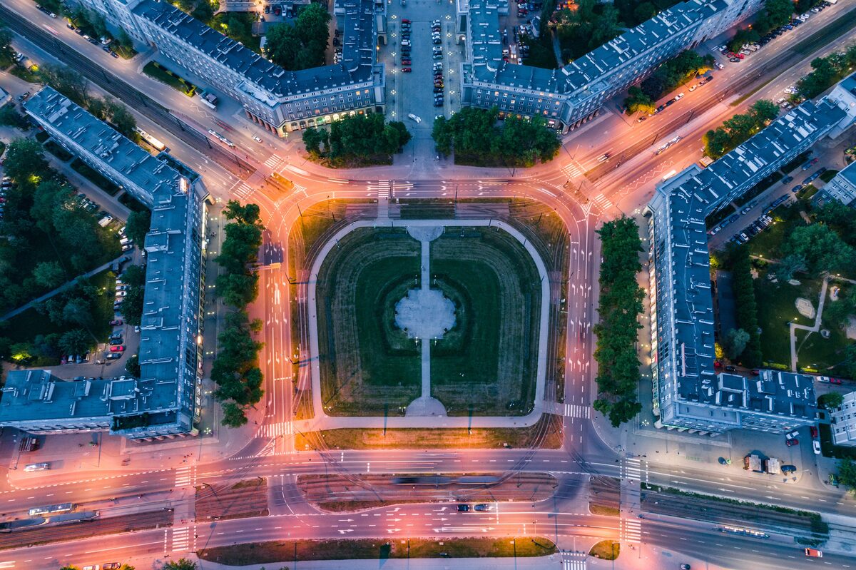 Nowa Huta's Central Square from directly above at dusk, a lawn surrounded by apartment blocks with avenues fanning out from it