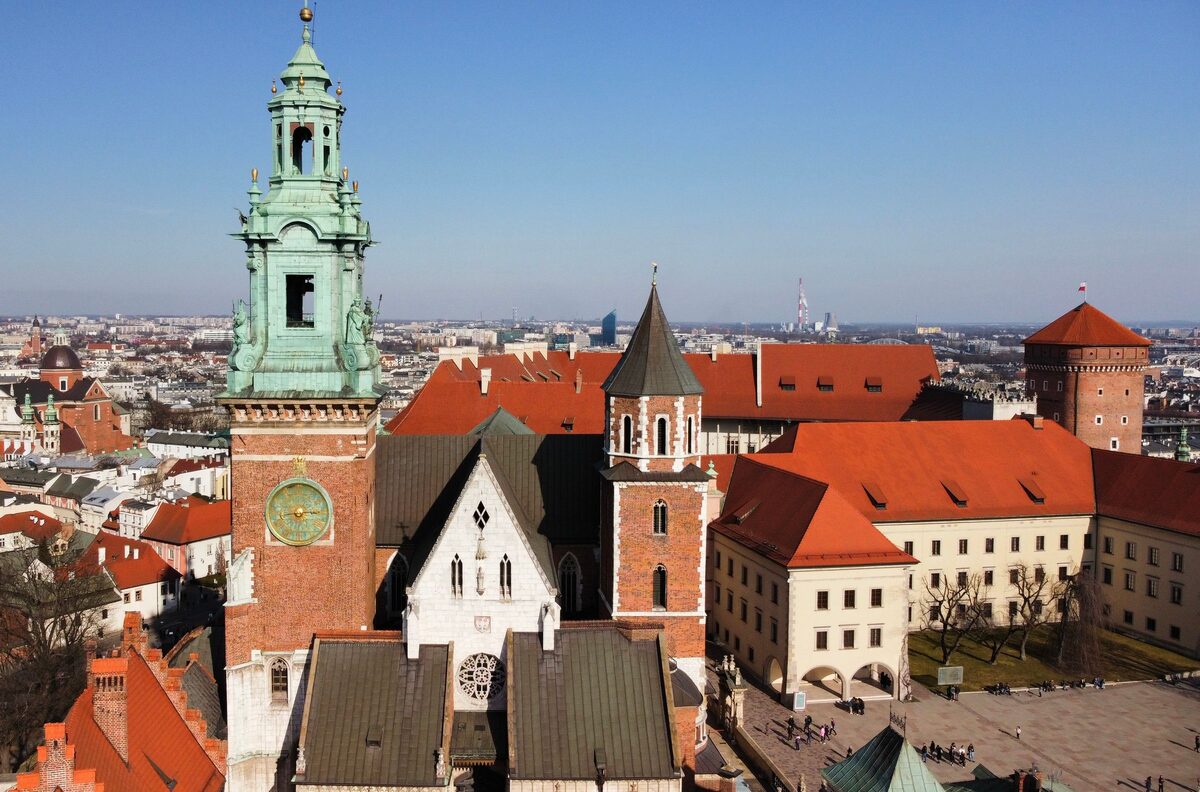 Wawel Cathedral from above, with its green-domed clock tower, Gothic chapels and the red roofs of the castle behind it