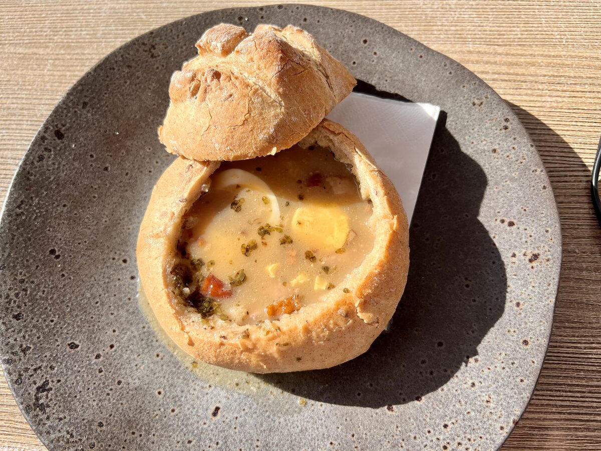 Żurek sour rye soup with egg and sausage served inside a hollowed-out round loaf of bread