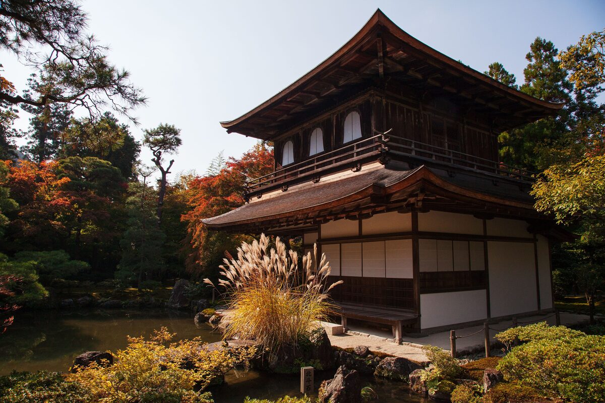 The two-storey wooden Silver Pavilion of Ginkaku-ji beside its pond, with pampas grass and autumn maples around it