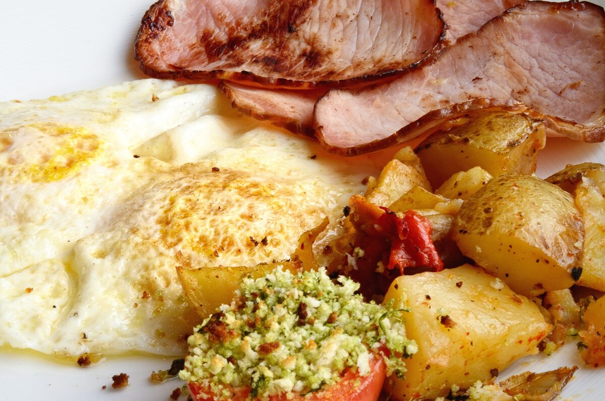 Fried eggs, thick bacon and home fries on a plate, the classic diner breakfast