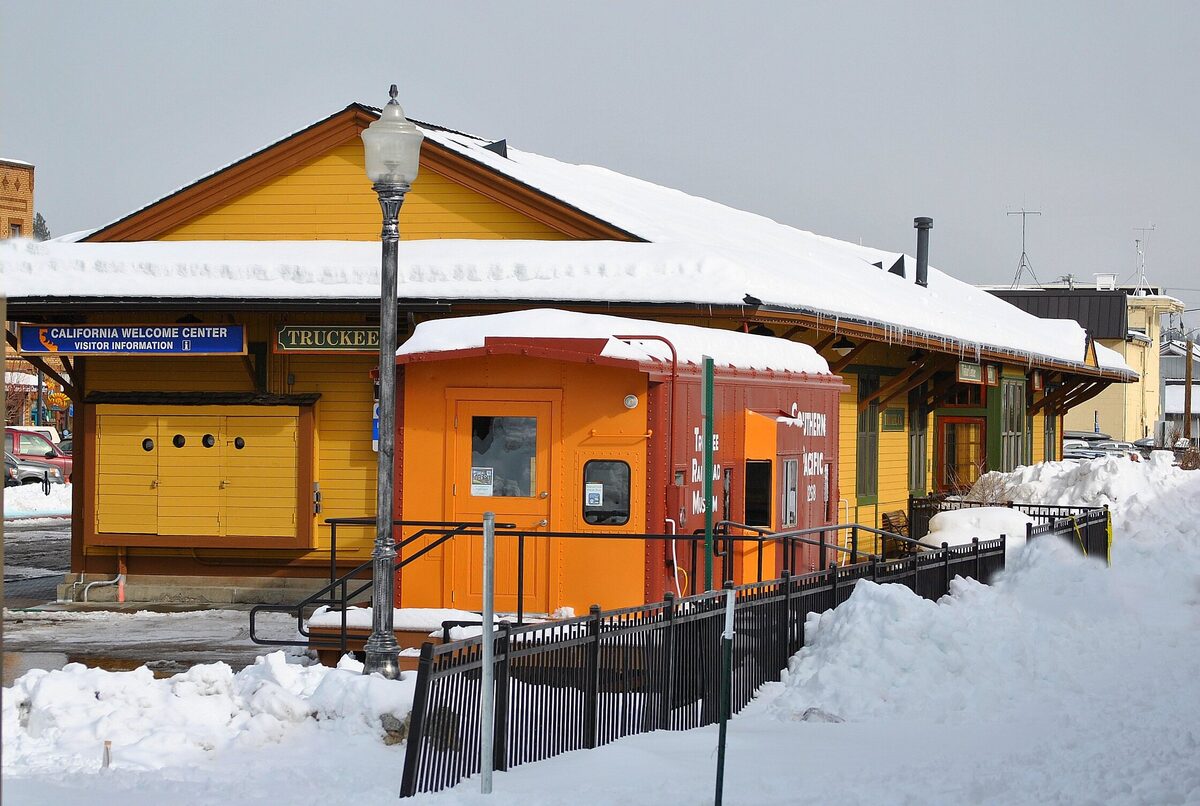 The Truckee railroad depot in snow, its yellow station building beside the tracks