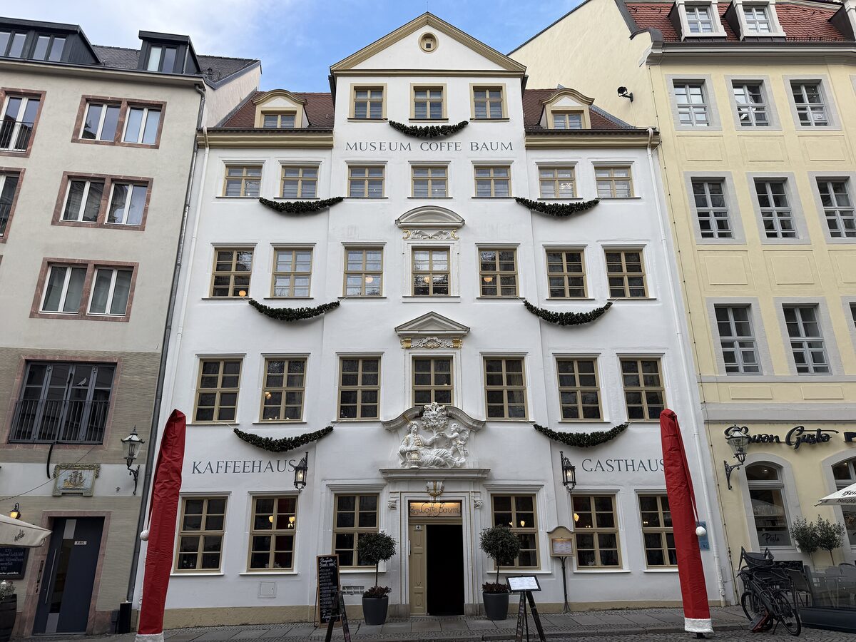 The white Baroque facade of the Coffe Baum on Kleine Fleischergasse, with the museum and café signs above the door