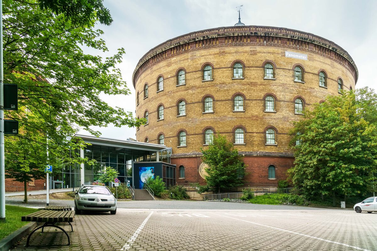 The round brick Panometer, a former gas tank, with trees and the entrance building in front