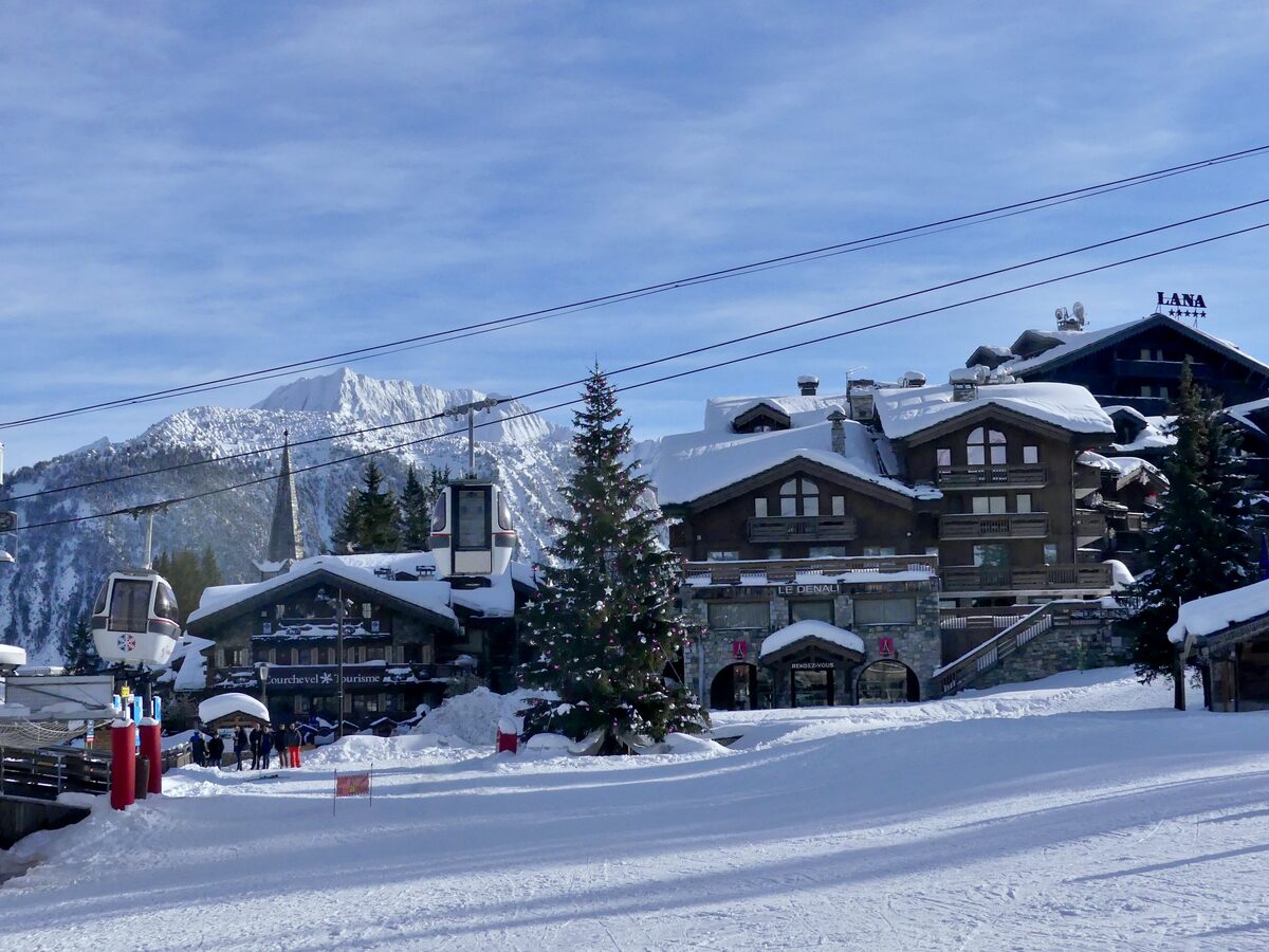 Snowy chalets and a gondola station at the front de neige of Courchevel 1850