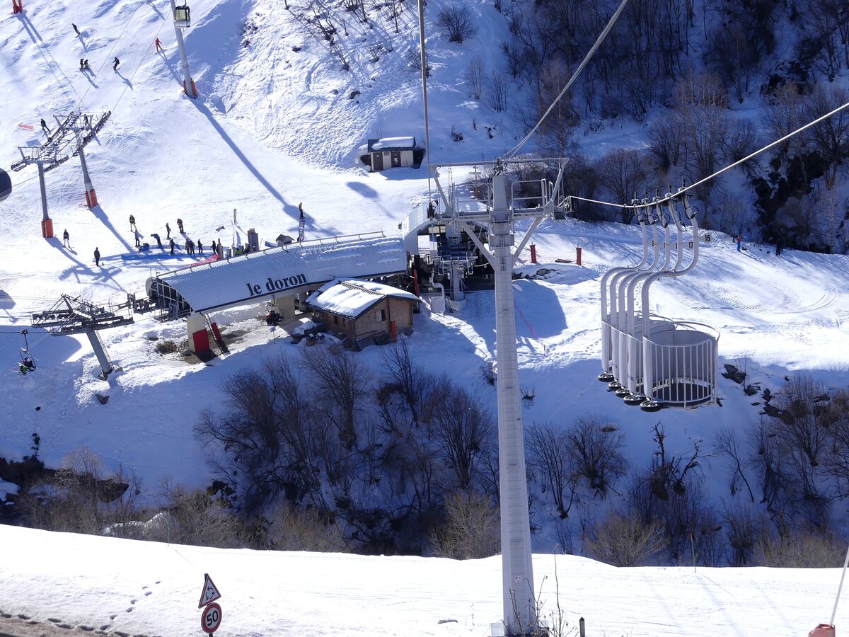 The Croisette gondola station in Les Menuires, with skiers on the snow