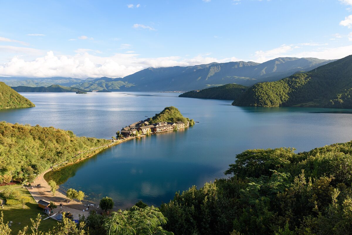 Lugu Lake seen from the Lige viewing deck, with a small peninsula and forested mountains