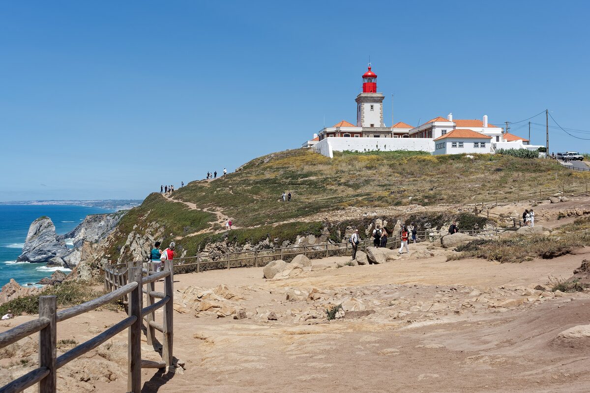 The red-topped lighthouse on Cabo da Roca, with a grassy headland and cliffs