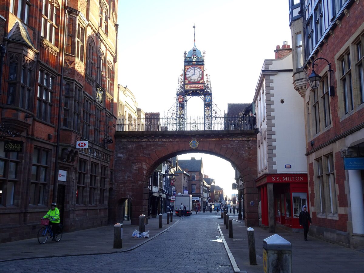 The ornate Eastgate Clock in Chester, a Victorian clock on a lacy iron frame above the city gate and the street below